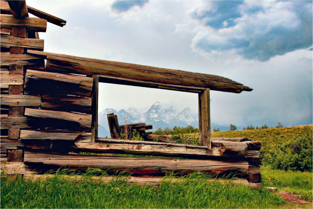 “Cabin with a View”—a fine art print of a weathered Wyoming cabin framing the Tetons under moody skies. 