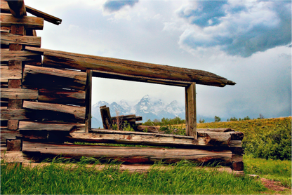 “Cabin with a View”—a fine art print of a weathered Wyoming cabin framing the Tetons under moody skies. 